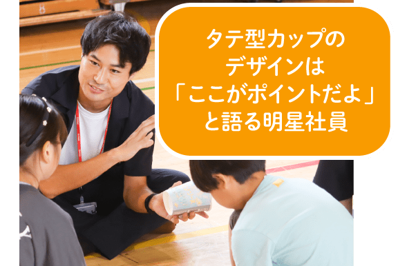 タテ型カップのデザインは「ここがポイントだよ」と語る明星社員